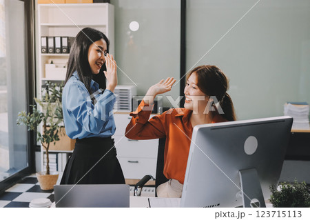 Group of Young Asian business team creative businesspeople coworker in office Happy to be successful partnership teamwork celebrating achievement and success concept. 123715113