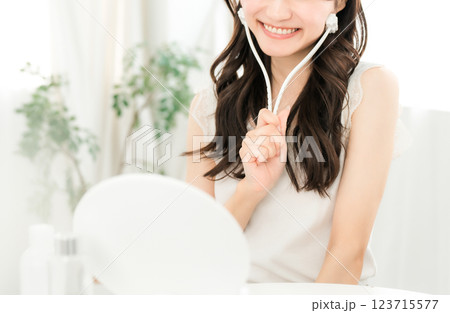 美顔ローラーを使ってマッサージするアジア人女性 美顔ローラーを使ってマッサージするアジア人女性 123715577