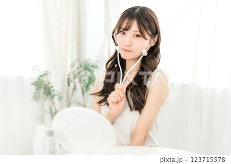 美顔ローラーを使ってマッサージするアジア人女性 123715578