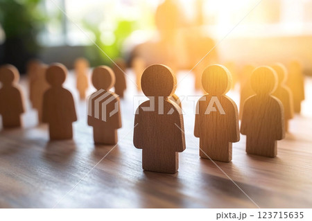 HR and business concept with a light wooden background featuring blue icons representing teamwork, success, and workplace collaboration. Abstract symbols of people and teams highlight 123715635