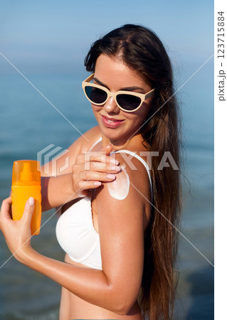 Enjoying Summer by the Beach While Applying Sunscreen for Skin Protection and Care Enjoying Summer by the Beach While Applying Sunscreen for Skin Protection and Care 123715884