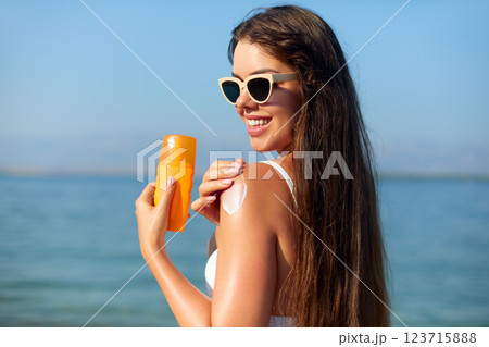 Applying Sunscreen While Enjoying Summer at the Beach to Protect Skin From Sun Damage and Maintain Healthy Skincare Routine Applying Sunscreen While Enjoying Summer at the Beach to Protect Skin From Sun Damage and Maintain Healthy Skincare Routine 123715888