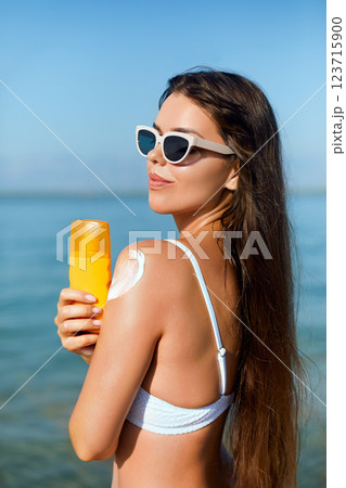 Beauty Woman applying sunscreen creme on tanned shoulder. Skincare. Body Sun protection Beauty Woman applying sunscreen creme on tanned shoulder. Skincare. Body Sun protection 123715900