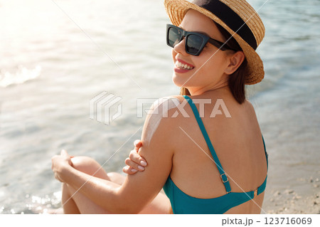 Beautiful Woman in Bikini Applying Sun Cream on Tanned Shoulder. Sun Protection. Skin and Body Care. Girl Using Sunscreen to Skin. Beautiful Woman in Bikini Applying Sun Cream on Tanned Shoulder. Sun Protection. Skin and Body Care. Girl Using Sunscreen to Skin. 123716069