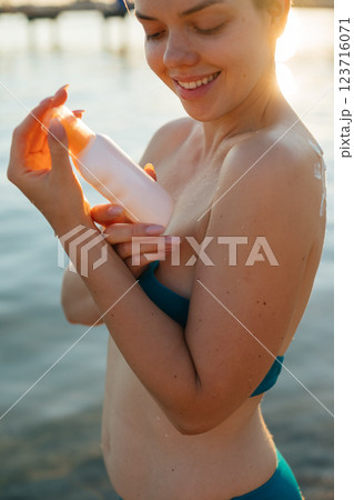 Beautiful Woman in Bikini Applying Sun Cream on Tanned Shoulder. Sun Protection. Skin and Body Care. Girl Using Sunscreen to Skin. 123716071