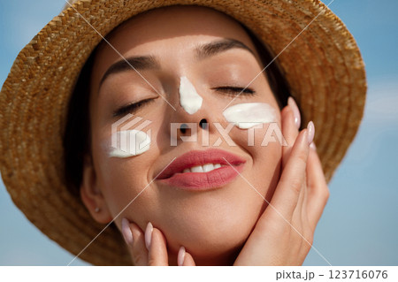 Beautiful Young woman with sun cream on face. .Skin care. Sun protection. Sunta 123716076