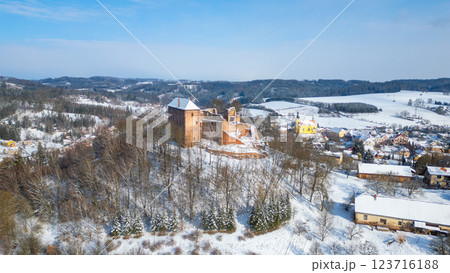 Pecka castle stands majestically amid a winter landscape, blanketed in snow. The surrounding village and hills create a picturesque setting, showcasing the beauty of Czechia in the cold season. 123716188
