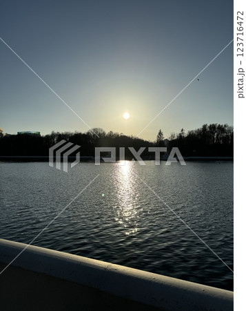 Tranquil sunset over calm lake with golden reflections Tranquil sunset over calm lake with golden reflections 123716472