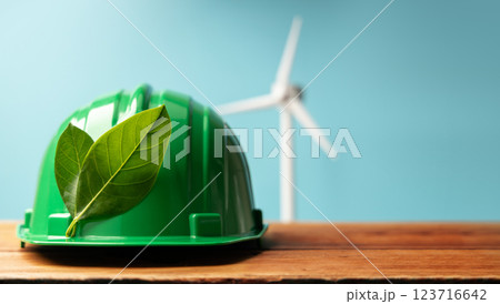 ESG and Clean Energy Concept. Hard Hat with Green Leaf. Wind Turbine Generator as background. Produce a Green Power. World Earth Day, Sustainable Resources, Environmental Care ESG and Clean Energy Concept. Hard Hat with Green Leaf. Wind Turbine Generator as background. Produce a Green Power. World Earth Day, Sustainable Resources, Environmental Care 123716642