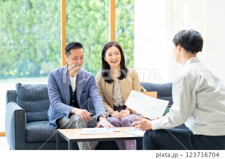 夫婦に商談をするビジネスマン 夫婦に商談をするビジネスマン 123716704