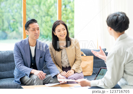 夫婦に商談をするビジネスマン 夫婦に商談をするビジネスマン 123716705