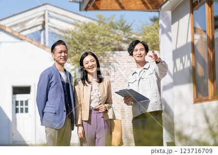 リフォームの打ち合わせをするビジネスマンとミドル夫婦 リフォームの打ち合わせをするビジネスマンとミドル夫婦 123716709