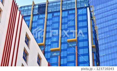 View of an modern apartment building standing next to a new modern office building with a glass facade. 123716843