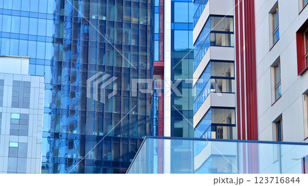 View of an modern apartment building standing next to a new modern office building with a glass facade. View of an modern apartment building standing next to a new modern office building with a glass facade. 123716844