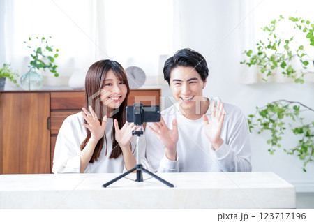 笑顔で動画撮影をする男女 123717196