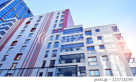 View of an modern apartment building standing next to a new modern office building with a glass facade. 123718299