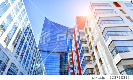 View of an modern apartment building standing next to a new modern office building with a glass facade. 123718312
