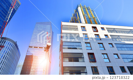 View of an modern apartment building standing next to a new modern office building with a glass facade. 123718322