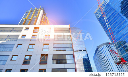 View of an modern apartment building standing next to a new modern office building with a glass facade. 123718325