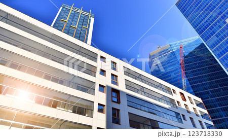 View of an modern apartment building standing next to a new modern office building with a glass facade. 123718330