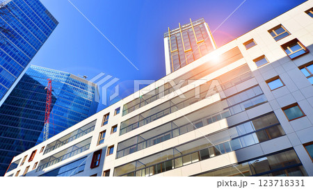 View of an modern apartment building standing next to a new modern office building with a glass facade. 123718331