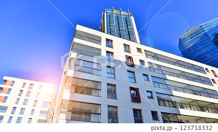 View of an modern apartment building standing next to a new modern office building with a glass facade. 123718332