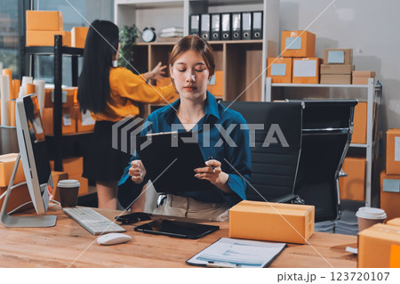 Asian SME business women use laptop computer checking customer order online shipping boxes at home. Starting Small business entrepreneur SME freelance. Online business, Work at home concept. 123720107