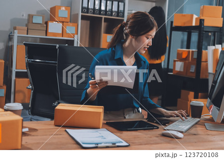 Asian SME business women use laptop computer checking customer order online shipping boxes at home. Starting Small business entrepreneur SME freelance. Online business, Work at home concept. 123720108