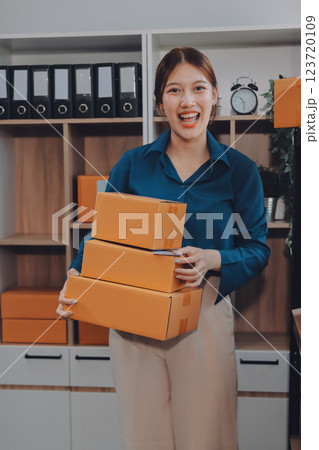 Asian SME business women use laptop computer checking customer order online shipping boxes at home. Starting Small business entrepreneur SME freelance. Online business, Work at home concept. 123720109