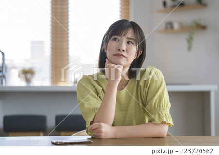 頬杖をついて考え込むアラサーの女性 123720562