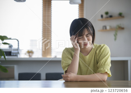 頭を抱えるアラサーの女性 123720656