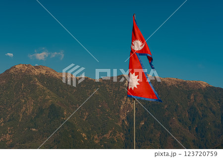 Nepal flag against green hills and blue sky with copy space 123720759