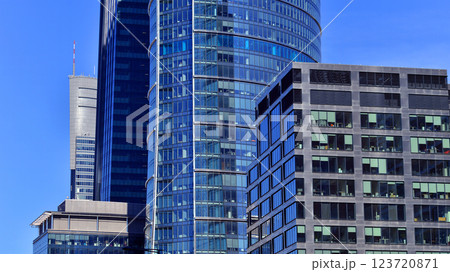Glass building with transparent facade of the building and blue sky. Structural glass wall reflecting blue sky. Abstract modern architecture fragment. Contemporary architectural background. 123720871