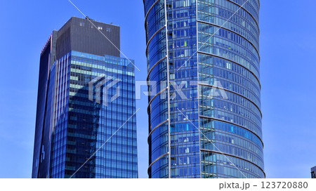 Glass building with transparent facade of the building and blue sky. Structural glass wall reflecting blue sky. Abstract modern architecture fragment. Contemporary architectural background. 123720880