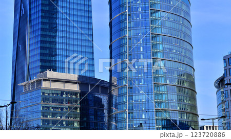 Glass building with transparent facade of the building and blue sky. Structural glass wall reflecting blue sky. Abstract modern architecture fragment. Contemporary architectural background. 123720886