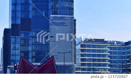 Glass building with transparent facade of the building and blue sky. Structural glass wall reflecting blue sky. Abstract modern architecture fragment. Contemporary architectural background. 123720887