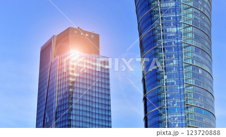 Glass building with transparent facade of the building and blue sky. Structural glass wall reflecting blue sky. Abstract modern architecture fragment. Contemporary architectural background. 123720888
