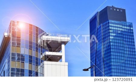 Glass building with transparent facade of the building and blue sky. Structural glass wall reflecting blue sky. Abstract modern architecture fragment. Contemporary architectural background. 123720891