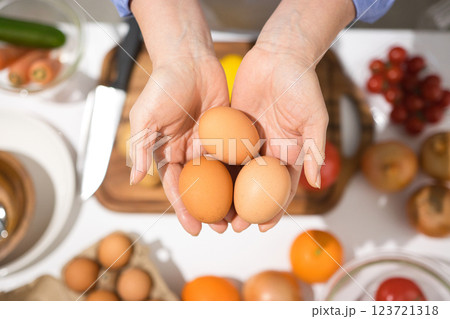 新鮮な卵を持つミドル女性の手 123721318