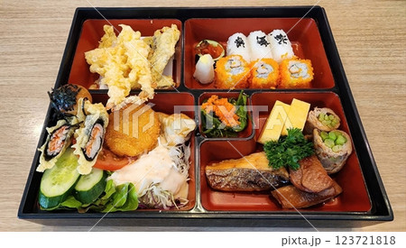 Colorful Japanese Bento Box with Sushi, Tempura, and Fresh Vegetables 123721818
