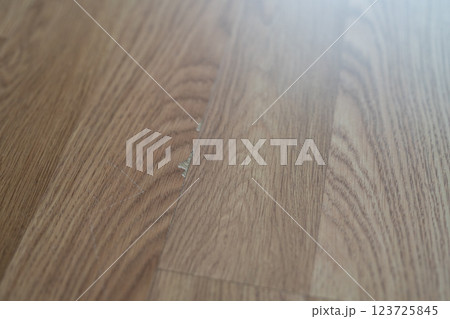 Laminate flooring with visible defects like chips, cracks, and unevenness. 123725845