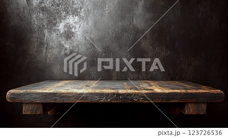 A rugged wooden table stands against a textured dark wall. Concept of vintage simplicity. 123726536