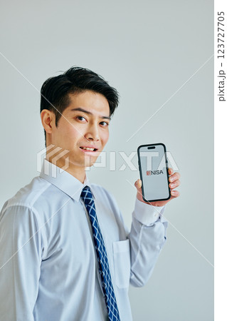 スマホを持つ20代の若い男性 新NISA スマホを持つ20代の若い男性 新NISA 123727705