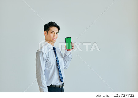 スマホを持つ20代の若い男性　グリーンバック 123727722