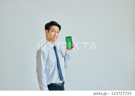 スマホを持つ20代の若い男性　グリーンバック 123727725