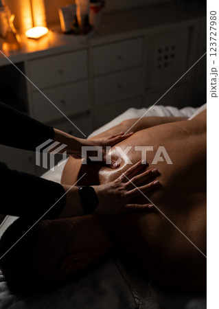 Woman masseuse doing professional back massage to man in spa salon. 123727980