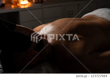 Woman masseuse doing professional back massage to man in spa salon. 123727984