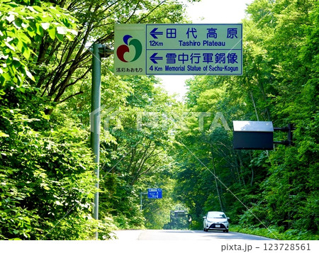 青森　国道394号線　田代高原と雪中行軍銅像への道路標識がある風景　青森県十和田市 123728561