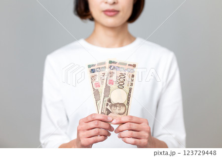一万円札を持つミドル女性 123729448