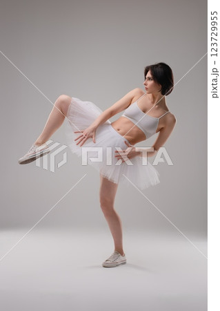 Elegant ballet dancer poses gracefully in lingerie at dance studio setting Elegant ballet dancer poses gracefully in lingerie at dance studio setting 123729955